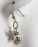 Silver elephant-shaped earring on a white background